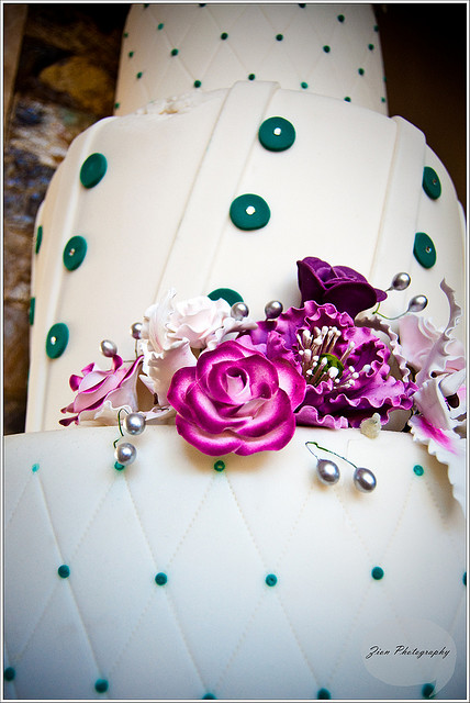 White cake teal and purple flower wedding cake
